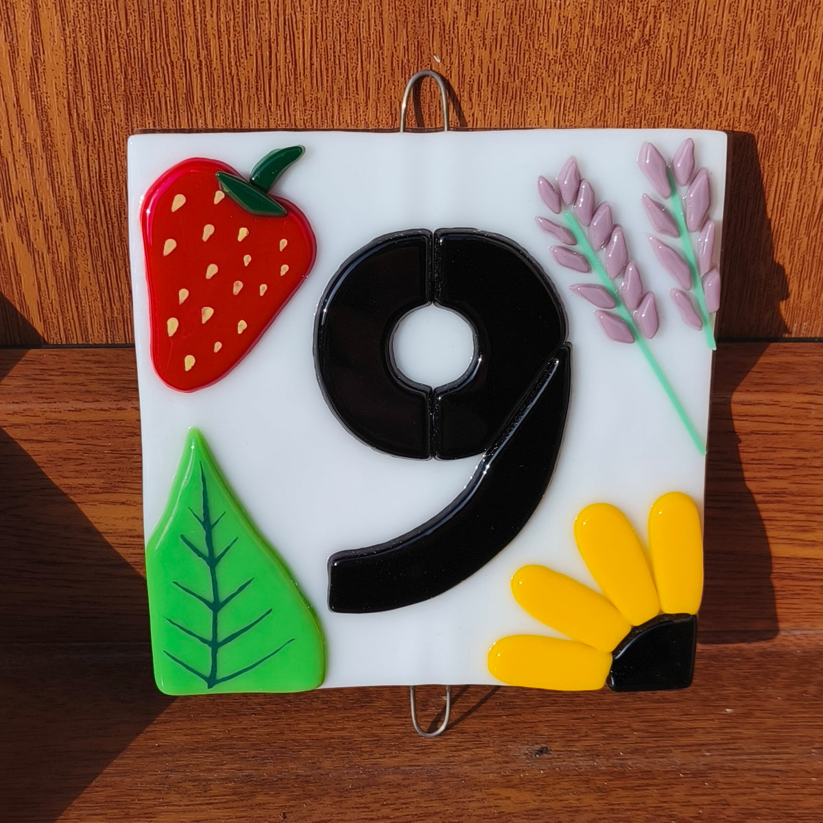 Numéro d'une maison en verre fondu avec décoration florale.