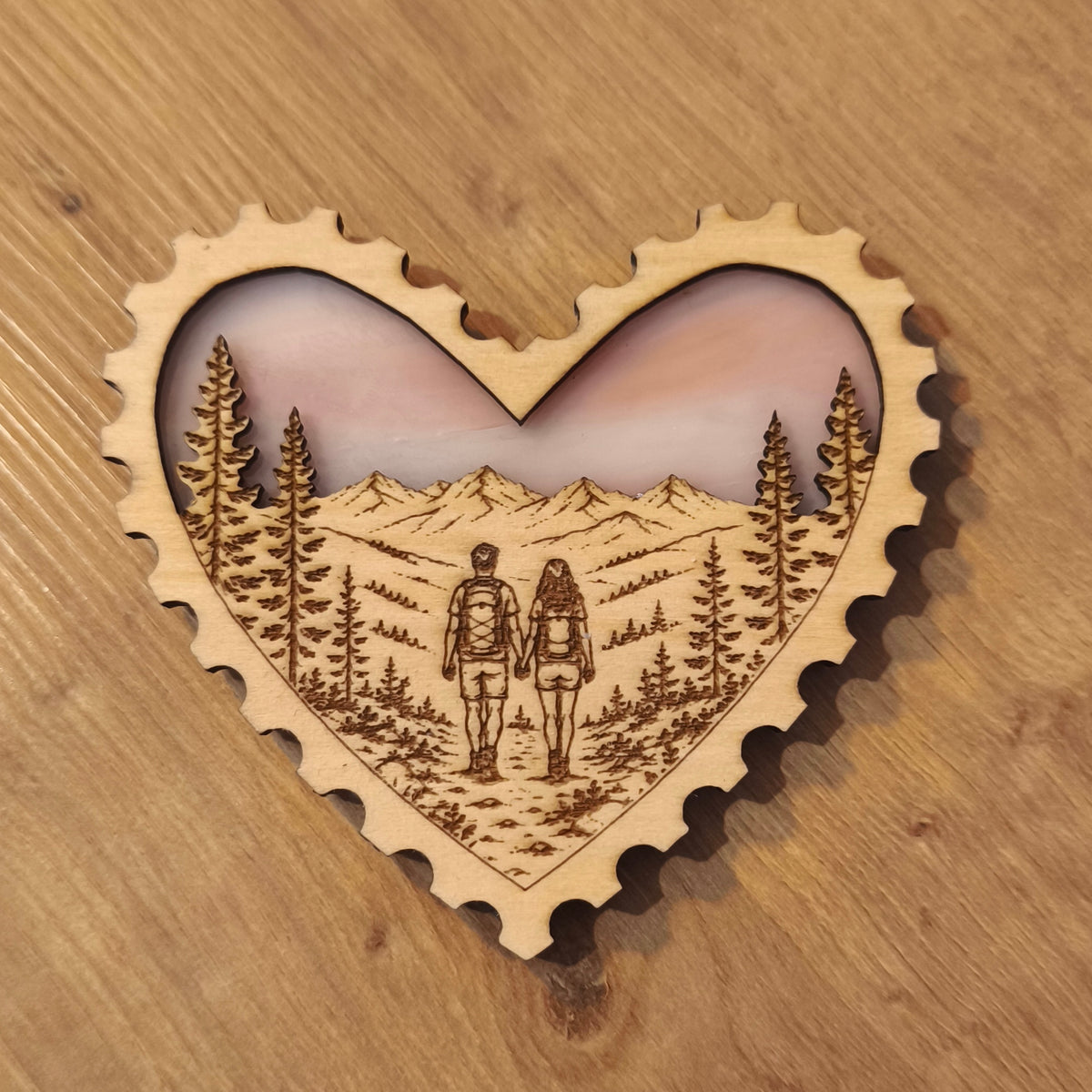 Aimant en bois gravé et en verre, représentant un couple de randonneur en forêt face aux montagnes