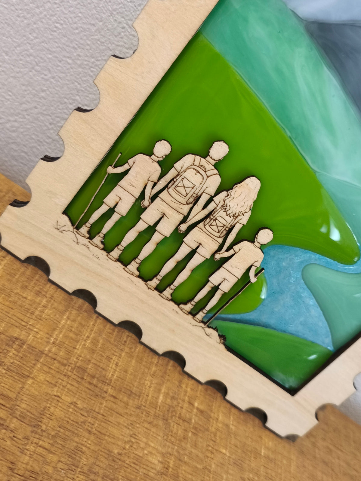 Décoration en verre fondu et en bois représentant une famille de randonneurs face à des montagnes