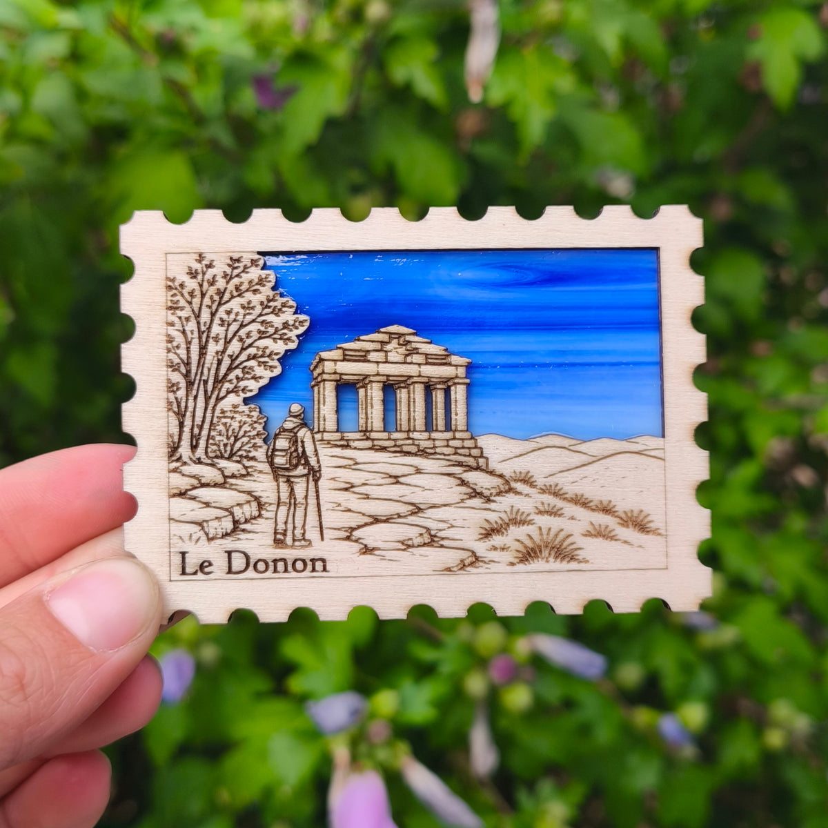 Aimant en verre et en bois gravé représentant le temple du Donon et un randonneur