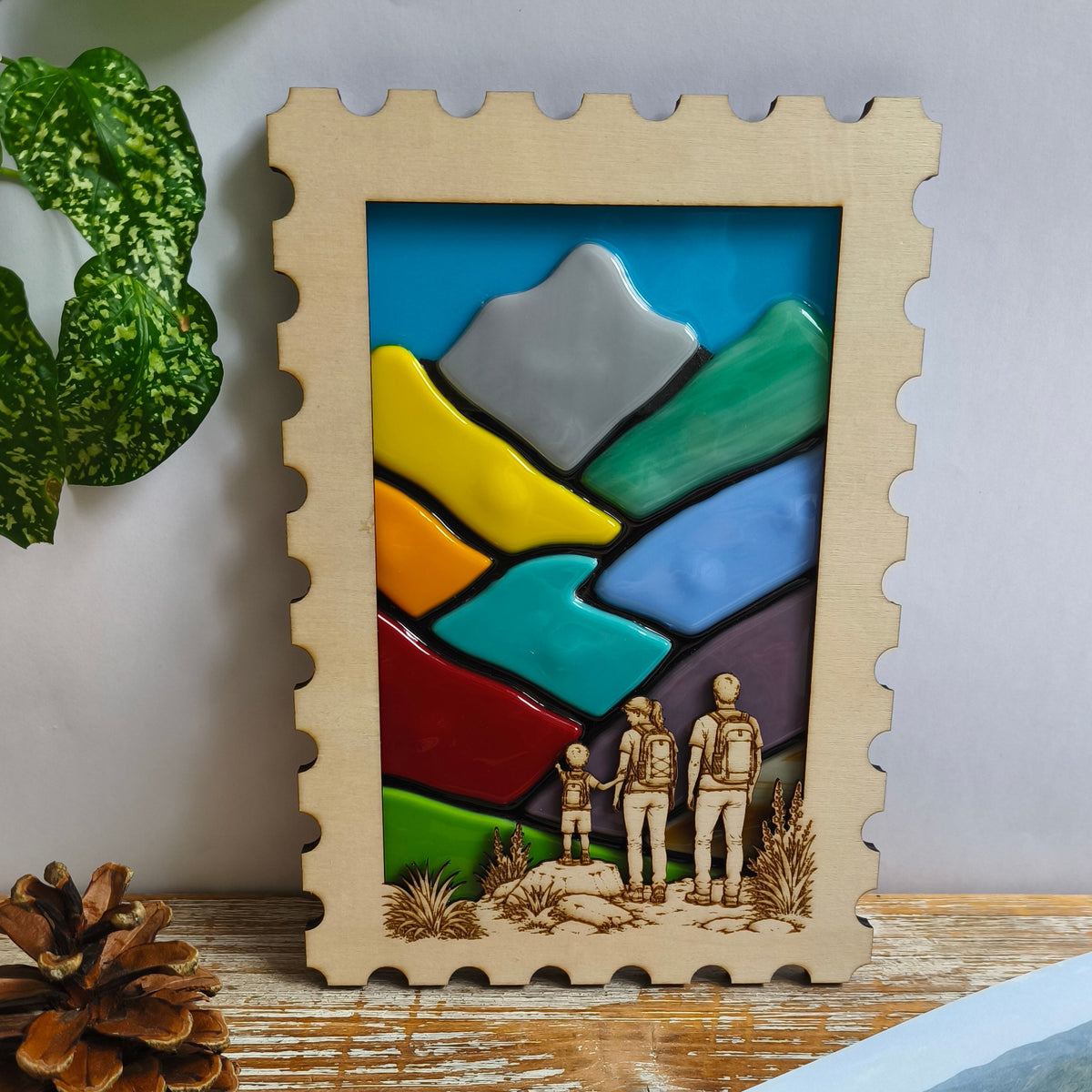 Décoration murale artisanale - paysage montagne en verre fondu - cadre en bois en forme de timbre – couple de randonneurs avec leur jeune enfant