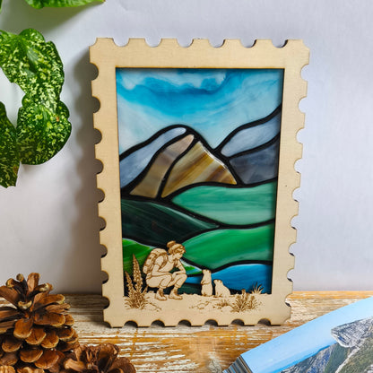 Décoration murale artisanale - paysage montagne en verre fondu - cadre en bois en forme de timbre – randonneuse accroupie face à deux marmottes