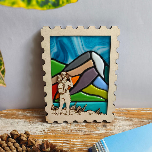 Décoration murale artisanale - paysage montagne en verre fondu - cadre en bois en forme de timbre – randonneuse qui photographie une montagne avec son appareil photo